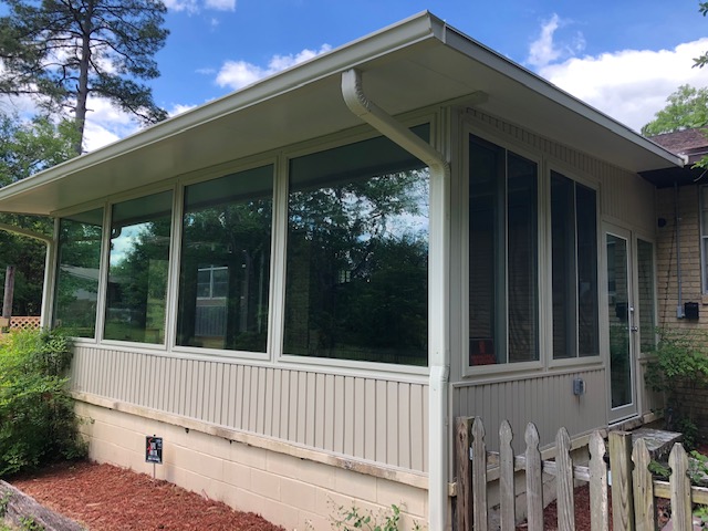 Exterior view of glass room with vinyl siding